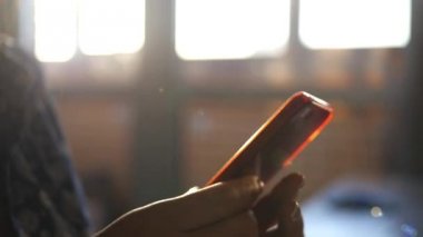 gün batımında telefon ile kadının el