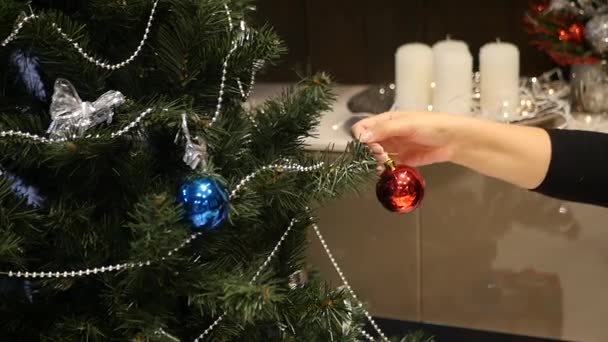 Superam bola de Natal de um ramo para outro, no fundo de guirlandas e velas, câmera lenta — Vídeo de Stock