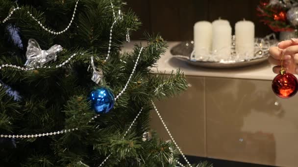 Einen Weihnachtsbaum zu schmücken, alles schön aufzuhängen, die Weihnachtsbaumordnung einzuführen, Zeitlupe — Stockvideo