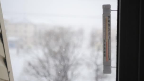 Θερμόμετρο στο παράθυρο με την εστίαση σχετικά με την κυκλοφορία της νιφάδες χιονιού στο δρόμο — Αρχείο Βίντεο