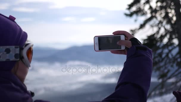 年轻女孩在滑雪斜坡照片电话景观，4 k — 图库视频影像