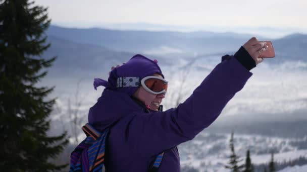 Красивая молодая девушка делает селфи на лыжных склонах, 4k — стоковое видео