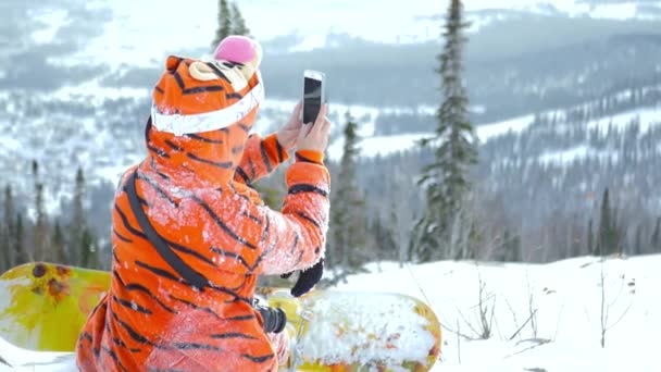 Menina snowboard faz belo panorama de montanhas cobertas de neve, 4k — Vídeo de Stock