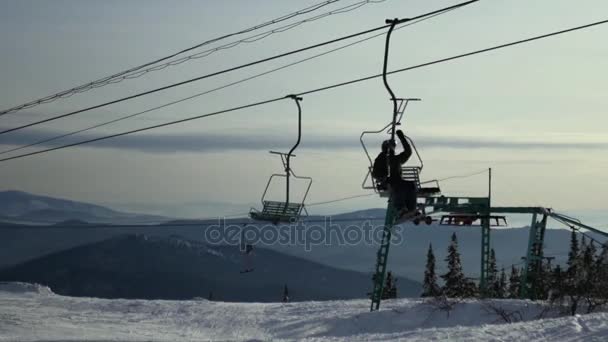 Лыжники едут на лифте по опорному столбу. 4k. Россия, Таштагол, Шерегеш, 4 декабря 2016 года — стоковое видео