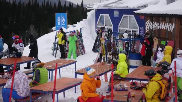 Banyak pemain ski dan snowboarder yang minum teh di sebuah kafe di luar ruangan pada musim dingin, 4k. Rusia, Tashtagol, Sheregesh, 4 Desember 2016 4k — Stok Video