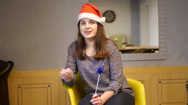 Joven hermosa mujer felicita feliz año nuevo, lee la felicitación con la hoja. HD — Vídeo de stock