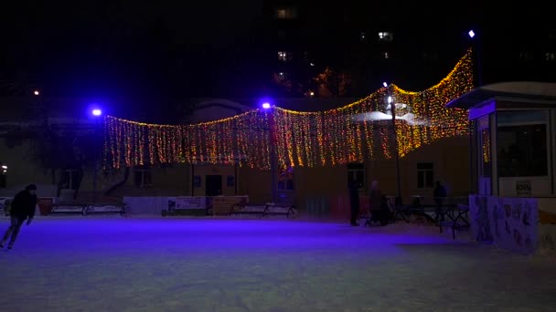 Молодий чоловік взимку катається на ковзанах в парку, повільний рух — стокове відео