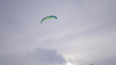 uçurtma rüzgar yakalamak için kanat ve havada bir genç adam, 4 k denetim altında dönmeye başladı