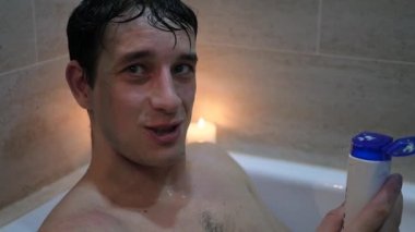 gülümseyen ve saçımı yavaş yıkayacak banyoda iyi bir ruh hali içinde oturan bir genç adam