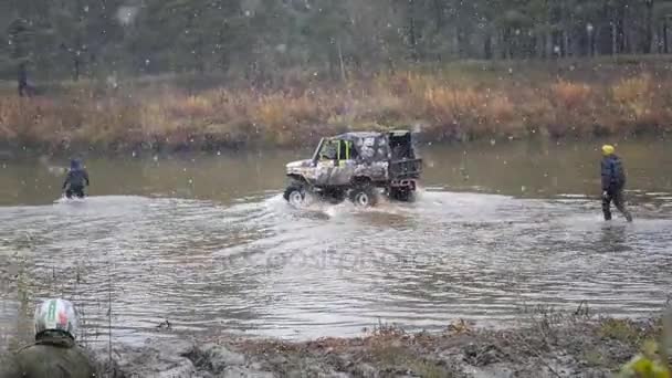 11. 10. 16, Russia, Novosibirsk, Salair Rubilovo. In tempo nevoso, il fiume attraversa la jeep e diversi uomini vanno a piedi, HD . — Video Stock