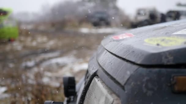 Крупный план капота автомобилей с падающим снегом на фоне осенней поляны, замедленное движение — стоковое видео