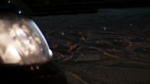 Snöflingor faller på natten mot bakgrund av bilstrålkastare, Slowmotion — Stockvideo