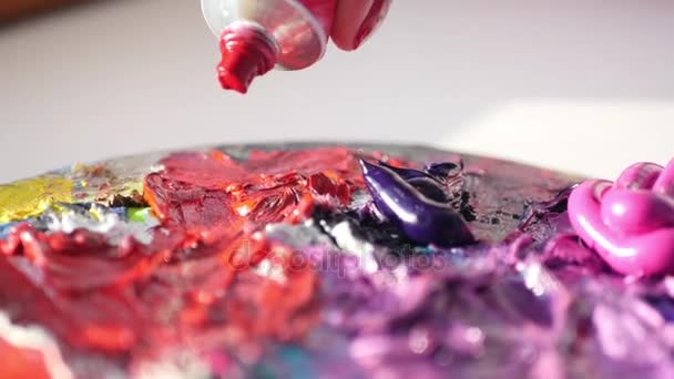 De samendrukking van de kunstenaar uit de buis op pallets rode olieverf, 4k — Stockvideo