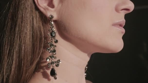 Красивые серьги мерцают с прядением драгоценностей в ушах очаровательная девушка, стоящая в профиль, HD — стоковое видео