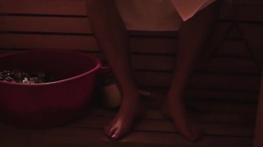 Banyoda bir rafta oturan güçlü genç adam ısıtılır. HD, 1920 x 1080