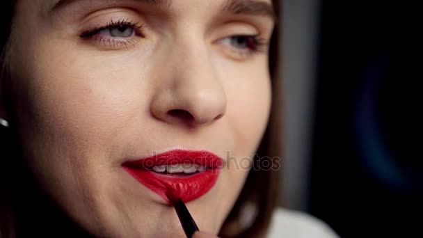 Hermosa chica pinta sus labios con lápiz labial rojo usando un cepillo de labios, HD, 1920x1080 . — Vídeo de stock