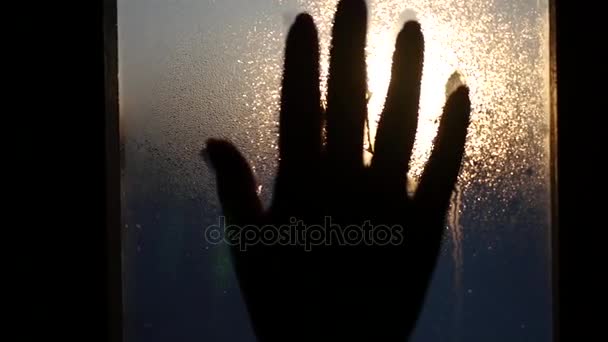 Para tocar la mano para caer sobre el vidrio contra el telón de fondo de una hermosa puesta de sol, deje una huella de mano con rayas gotas. HD, 1920x1080 . — Vídeo de stock