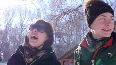 Geniş gülümseyerek, kameraya poz'de iki mutlu kız kış güneşli orman, iyi bir ısı. HD. 1920 x 1080