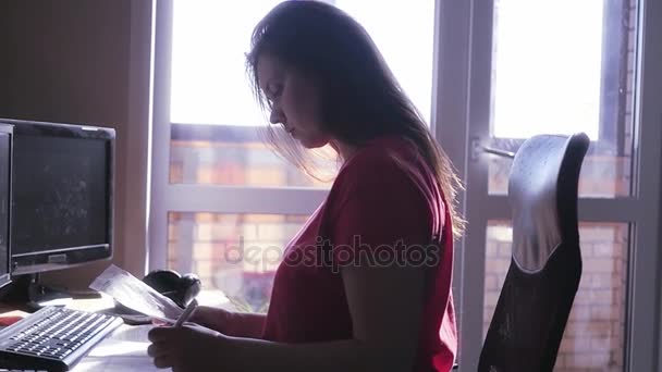 Una contadora joven, se sienta en la oficina y hace la contabilidad, entiende los cheques, apila en la calculadora. En cámara lenta. hd . — Vídeos de Stock