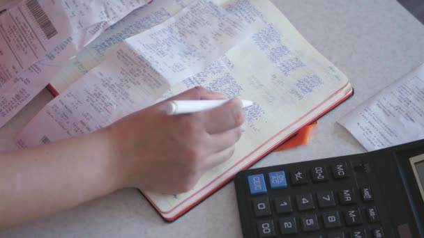 Het meisje steekt uit de getallen met behulp van de pen, de rekenmachine. 4k — Stockvideo