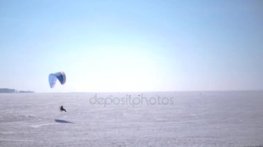 PA Yamaçparaşütü donmuş göl üzerinde şu ufuk üzerinde yükselir. HD 1080p.