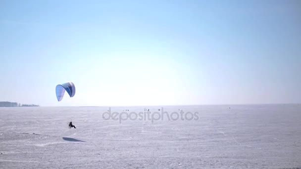 PA paraglider zweefvliegen op het bevroren meer recht aan de horizon. HD 1080p. — Stockvideo