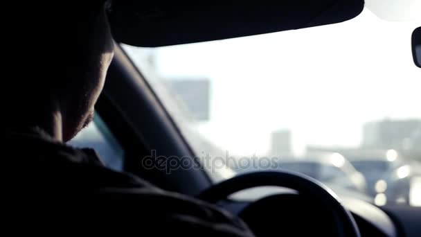 De man op de auto houdt vast aan het stuur, de zon schijnt fel en de reflectie van de lens effect in het glas. Slow-motion. 1920 x 1080. — Stockvideo