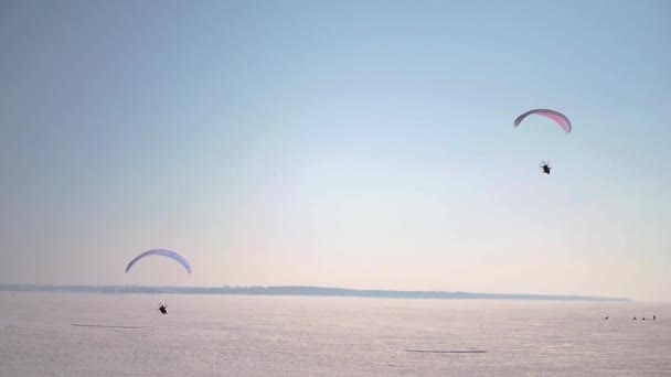 Due parapendio svettano dal suolo coperti di neve contro il cielo azzurro. Rallentatore. 1920x1080. HD — Video Stock