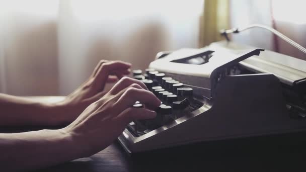 A menina imprime em uma bela máquina de escrever velha, com iluminação suave quente. Movimento lento. 1920x1080 . — Vídeo de Stock