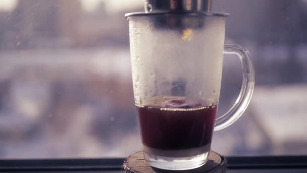 Membuat kopi di Asia, setetes jatuh ke dalam mangkuk kaca. Terhadap latar belakang pemandangan musim semi kota. 1920x1080. gerak lambat — Stok Video