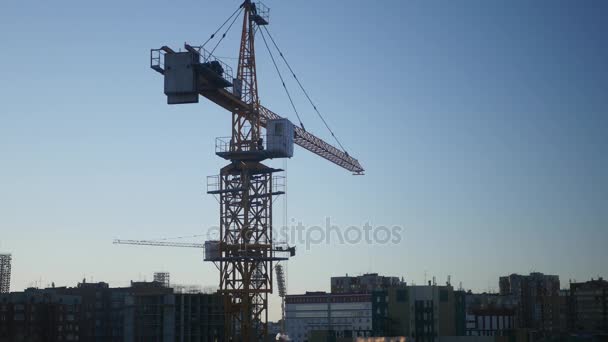 Big building crane in the city on the background of houses and sky. 4k, 3840x2160 — Stock Video