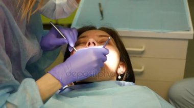 Genç bir doktor hastaların diş inceliyor. 4 k. 3840 x 2160