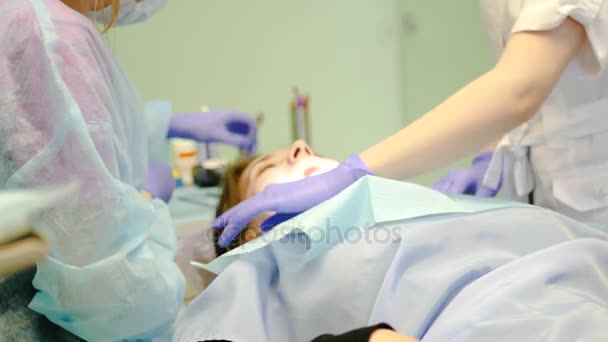 Paciente menina deitada em uma cadeira especial na recepção, stomatologia, o médico examina os dentes. 4K. 3840x2160 — Vídeo de Stock