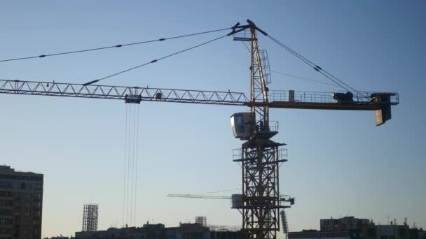 Construction crane in the blue sky and sunset in the sun. 4K — Stock Video