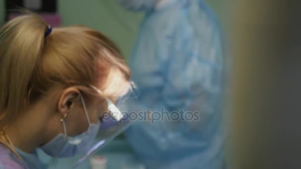 Le dentiste met le patient sur la bouche avec une protection spéciale en caoutchouc pour les lèvres et le visage. 4k. 3840x2160 — Video