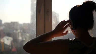 Neşeli bir genç kız, onun kulaklık penceresinde ve dansları güneş tarafından standları. SlowMo 1920 x 1080