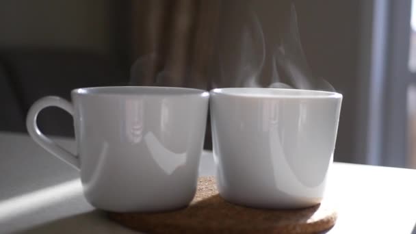 ホット コーヒーと太陽の下で蒸気の 2 つの白いカップ。スローモーション。1920 x 1080 Hd。 — ストック動画
