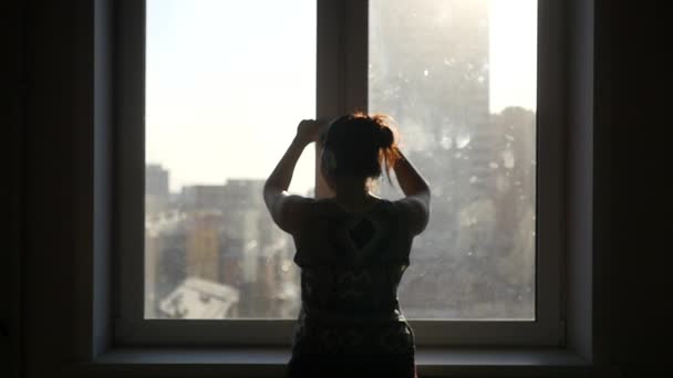 A lány megnyílik a windows a naplementét és a nap sugarai ellen. Slowmotion. 1920 x 1080 — Stock videók