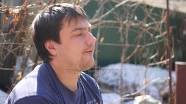 Duman exhaling yüzünde bir sigara oturan bir genç adam. 4k, 3840 x 2160. HD