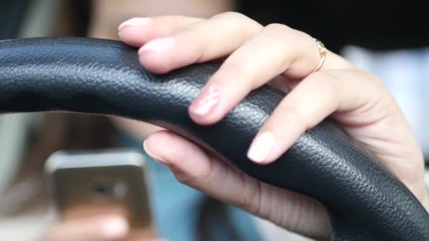 Eine junge Frau hält mit einer Hand ein Auto, die andere schaut auf etwas im Telefon. 4k. 30fps. 3840x2160 — Stockvideo