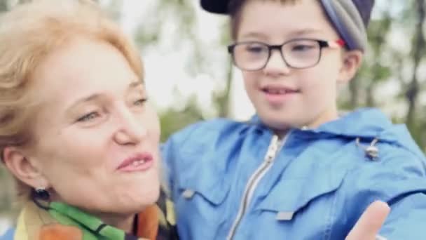 Mère tenant un enfant avec un garçon handicapé faisant pouce levé, souriant. 4k, 3840x2160. HD — Video