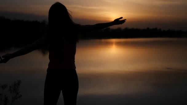 Πανέμορφο λεπτό κορίτσι βλέποντας το ηλιοβασίλεμα δίπλα στη θάλασσα, τα χέρια ψηλά. αργή κίνηση. 1920 x 1080 — Αρχείο Βίντεο
