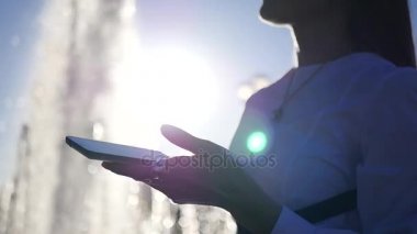 İş kadını onun telefonunda bir toplantıda şehrin çeşme bekleyen görünüyor. HD, 1920 x 1080.