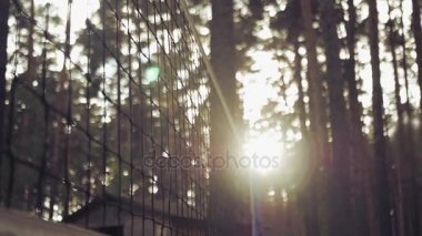 Voleybol günbatımında net orman içine düşüyor. Ağır çekim. HD, 1920 x 1080.