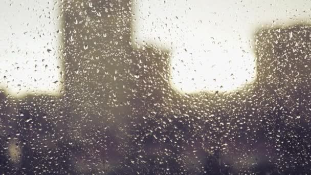 Droppar av regn på glaset på bakgrunden av hus i staden och solnedgången. 4k, 3840 x 2160. HD — Stockvideo