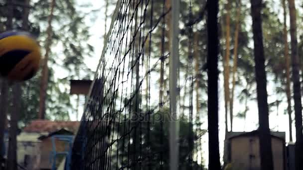 Voleibol azul bola amarilla golpea contra la red en la cancha en el bosque. Lento movimiento. HD, 1920x1080 . — Vídeos de Stock