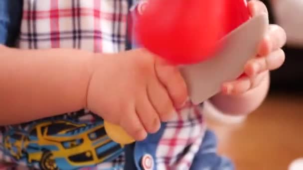 Niño juega en juguetes infantiles, cortes con cuchillo de plástico, tomate de plástico. Lento movimiento. HD, 1920x1080 . — Vídeos de Stock