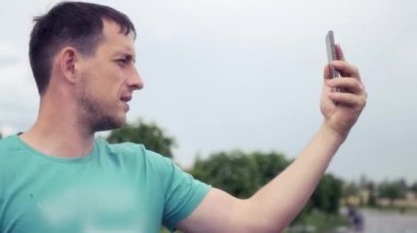 Genç bir adam telefonda iletişim, Hd, 1920 x 1080 video iletişim kurar. Ağır çekim