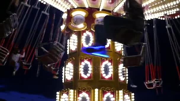 Een nachtelijke merry-go-round in de lichten, rolt mensen rond. HD, 1920 x 1080. Slow motion — Stockvideo