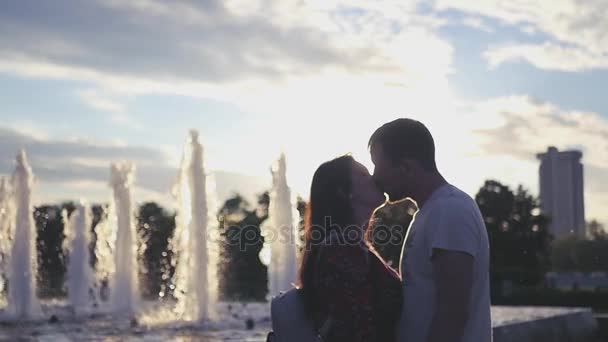 Amoroso casal entregando, beijando e abraçando fundo de fonte. HD, 1920x1080. Movimento lento — Vídeo de Stock